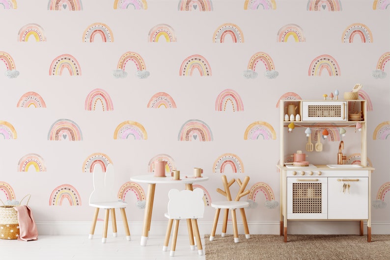Puede incluir: Una habitaci&oacute;n de beb&eacute; rosa con una cocina de juguete y una mesa y sillas. Las paredes est&aacute;n decoradas con un patr&oacute;n de arco&iacute;ris.