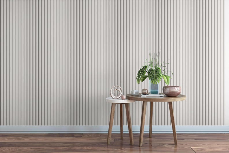 a minimalist interior design with a wooden table and two small side tables against a gray wall. The table has a plant and a bowl on it, creating a cozy and inviting atmosphere.