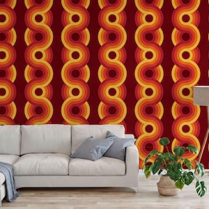 a living room with a white sofa, a potted plant, and a lamp. The walls are decorated with a vibrant, repeating pattern of circles in shades of red, orange, and yellow.