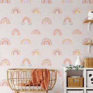 Puede incluir: Una habitaci&oacute;n de beb&eacute; con un papel tapiz rosa y blanco con un patr&oacute;n repetitivo de arco&iacute;ris coloridos. La habitaci&oacute;n tiene una cuna de mimbre, una estanter&iacute;a con cestas y una caja de almacenamiento con forma de panda, y una peque&ntilde;a planta.