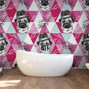 Puede incluir: Un ba&ntilde;o con un papel tapiz de patr&oacute;n geom&eacute;trico rosa, azul y blanco con un pug que lleva un sombrero. El papel tapiz est&aacute; en la pared detr&aacute;s de una ba&ntilde;era blanca.