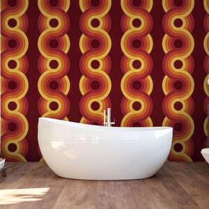 a modern bathroom with a large white freestanding bathtub, a wooden floor, and a vibrant, retro-style wall behind it.