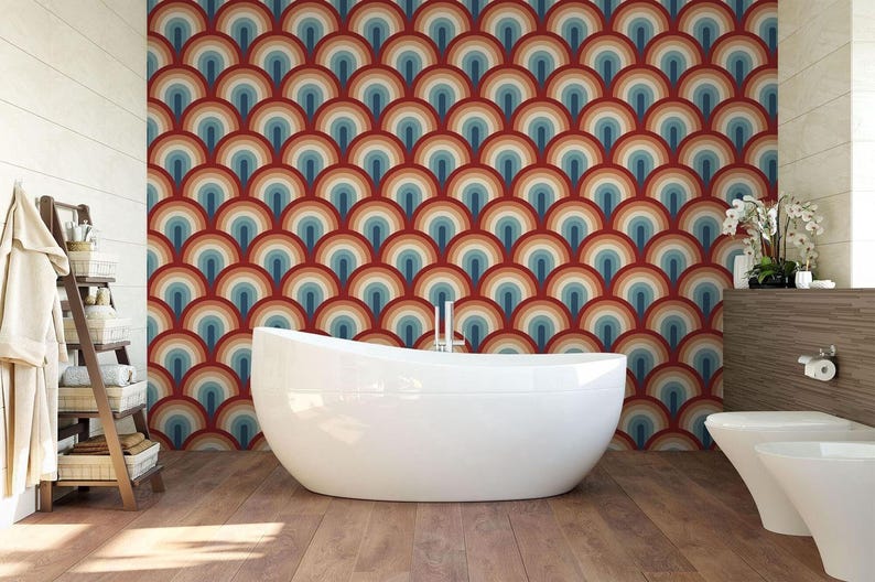 a modern bathroom with a large, white freestanding bathtub in the center. The walls behind the bathtub are covered in a vibrant, repeating pattern of circles in various colors, creating a visually striking and unique design. The bathroom also includes a toilet, a towel rack, and a potted plant, contributing to the overall aesthetic and functionality of the space.