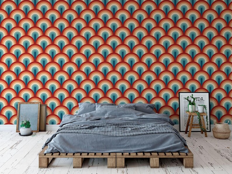 a bedroom with a bed, a wooden table, and a colorful, patterned wallpaper behind the bed.