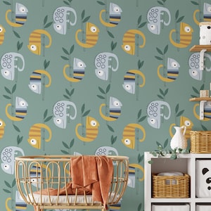 May include: A nursery room with a green wallpaper featuring a repeating pattern of blue and yellow chameleons on bamboo branches. The room includes a wicker bassinet, a white shelf with wicker baskets, and a white shelf with a panda-themed storage bin.