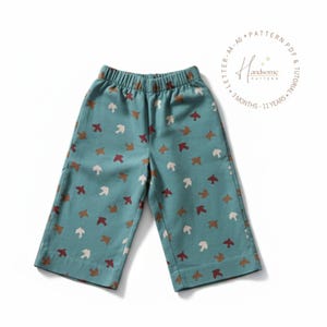 May include: Teal-colored, cropped pants with an elastic waistband and a repeating pattern of brown, white, and rust-colored birds. The pants are made of a soft fabric and are designed for children. The text "Handsome Pattern" is visible.