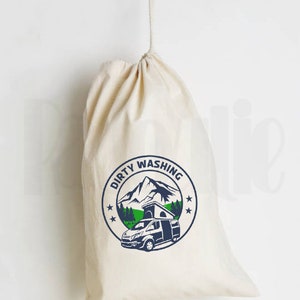 May include: A white canvas drawstring bag with the text "Dirty Washing" in blue and a graphic of a camper van in front of a mountain range.