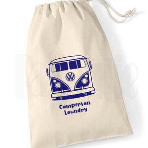 May include: A beige canvas laundry bag with a drawstring closure. The bag features a blue graphic of a campervan and the words "Campervan Laundry" in blue. The bag is designed for laundry.
