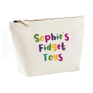 May include: A cream canvas pouch with a gold zip, featuring the text "Sophie's Fidget Toys" in colourful bubble letters. The pouch is designed to hold small items, such as fidget toys.