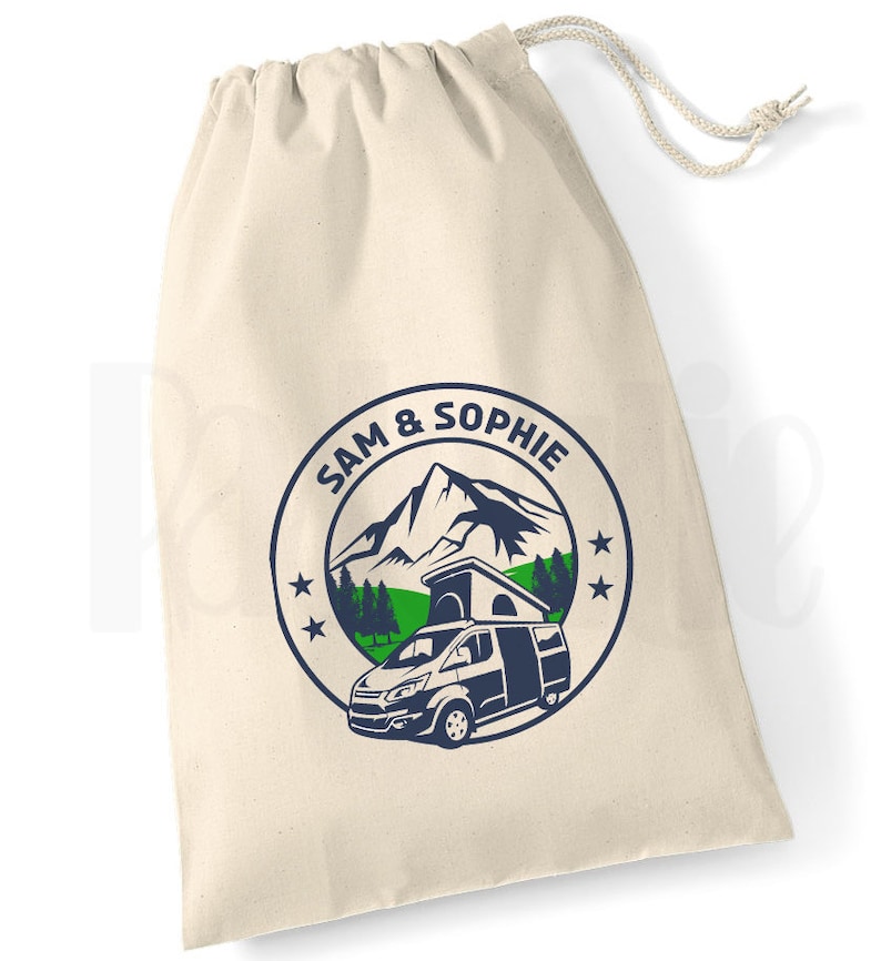 May include: A white canvas drawstring bag with a blue and green logo featuring a mountain, trees, and a camper van. The logo also includes the text "SAM & SOPHIE" in a circle.
