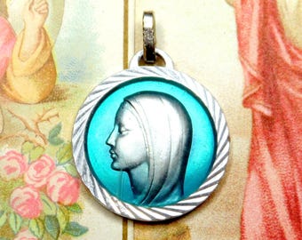 May include: Silver pendant with a blue enamel image of the Virgin Mary. The pendant has a silver chain and a detailed design.