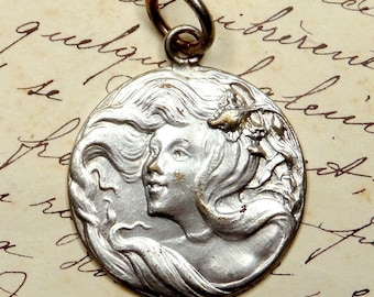 Woman with long hair with a flower. Antique Art Nouveau Pendant. Medal.