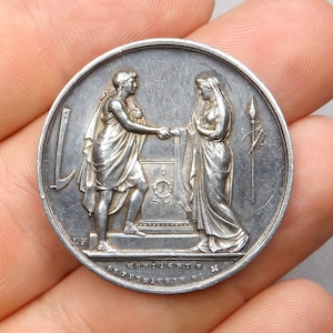 Peut inclure: Médaille d'argent représentant deux personnages se serrant la main. La médaille porte l'inscription "MONTAGNY F. DEPUTY MAURIN D.".