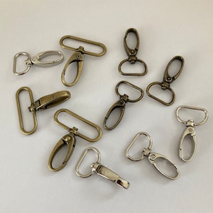 Puede incluir: Surtido de cierres y ganchos giratorios de metal en acabados plateado y dorado antiguo. Ideales para sujetar a bolsos, correas u otros accesorios.