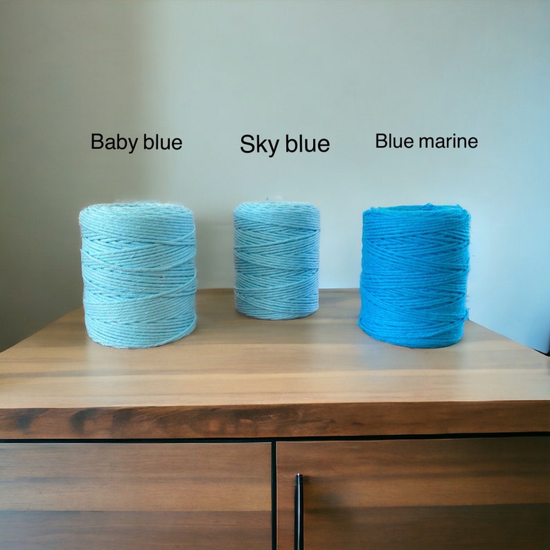 Może przedstawiać: Trzy szpulki nici w r&oacute;żnych odcieniach niebieskiego. Szpulki są oznaczone jako "Baby blue", "Sky blue" i "Blue marine".