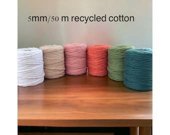 Op de afbeelding: Zes spoelen van 5 mm dik, 50 meter lang gerecycled katoenen touw in verschillende kleuren: wit, beige, roze, oranje, groen en teal.