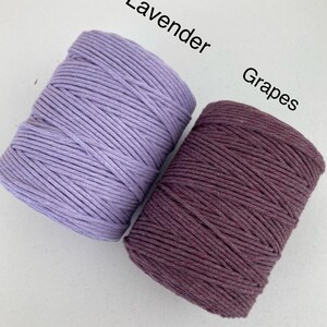 Może przedstawiać: Dwa bębny bawełnianego sznurka, jeden lawendowy, a drugi ciemnofioletowy, oznaczone jako "Lavender" i "Grapes".