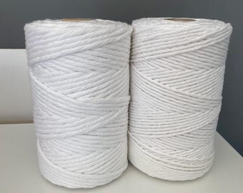 Pode incluir: Dois rolos de corda de algodão branca, cada um enrolado firmemente e pronto para projetos de artesanato.