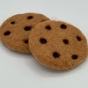 May include: Two brown felt chocolate chip cookies with dark brown chocolate chips.
