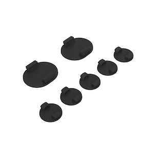 May include: A set of seven black plastic round bases of varying sizes. The bases have a raised lip around the edge and a small rectangular tab on the top.