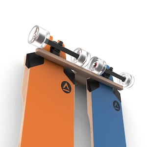 May include: Two skateboards mounted on a wooden wall rack. The skateboards are orange and blue with black triangle logos. The skateboards are hanging from the rack by their trucks.