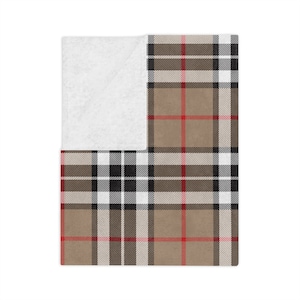 Può includere: Una coperta in plaid marrone, nero, bianco e rosso con un retro in pile bianco.