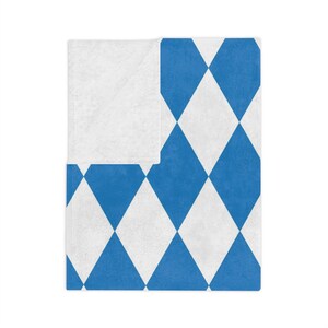 May include: A blue and white diamond patterned throw blanket. The blanket is folded in half and the pattern is visible on both sides.