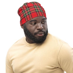 May include: A man wearing a red and green plaid beanie. The beanie has a  black and white pattern.