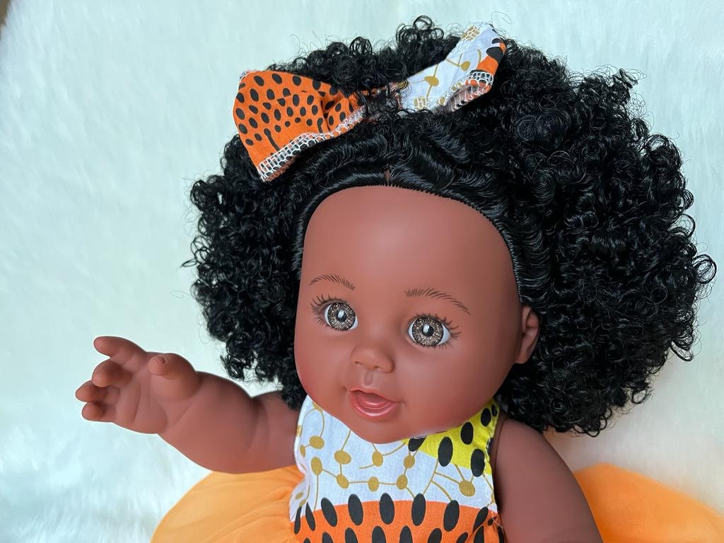 Bruine meisjes pop met krullend zwart haar in een jumpsuit met Afrikaanse printjes 30