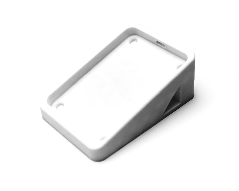 May include: White plastic phone stand with a raised edge and a triangular base.