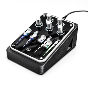 May include: A black audio mixer with four faders and four knobs. The mixer has a silver trim and a black and white logo that says "PC Panel".