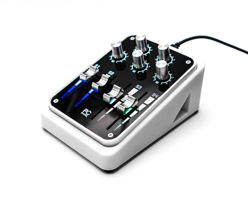 May include: A white audio mixer with a black faceplate and silver knobs. The faceplate has the text "PC Panel" and features sliders with blue and green lights.