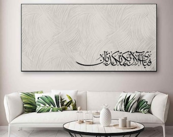 May include: A black and white abstract art print with Arabic calligraphy that reads "In the name of Allah, the Most Gracious, the Most Merciful". The print is framed and hanging on a white wall above a white couch with green and white throw pillows.