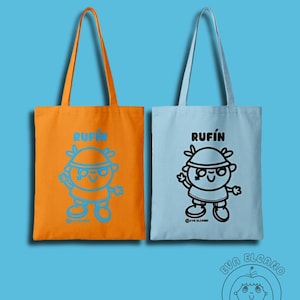 Może przedstawiać: Dwie torby, jedna pomarańczowa i jedna jasnoniebieska, z długimi uchwytami. Każda torba ma wz&oacute;r postaci z kresk&oacute;wki z napisem "RUFIN" nad nim. Pomarańczowa torba ma niebieski wz&oacute;r, a niebieska torba ma czarny wz&oacute;r.