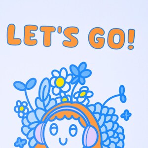 May include: A white print featuring the text "LET'S GO!" in orange. Below the text is a cartoon illustration of a person with orange hair wearing headphones, surrounded by blue flowers and leaves.