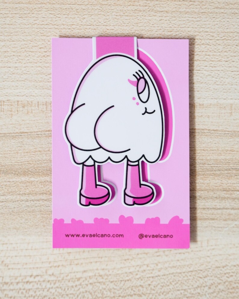 K&ouml;nnte beinhalten: Ein pinkfarbener Lesezeichen mit einer Cartoonfigur mit wei&szlig;em K&ouml;rper, rosa Stiefeln und einem l&auml;chelnden Gesicht. Auf dem Lesezeichen sind die Website www.evaelcano.com und der Instagram-Handle @evaelcano aufgedruckt.
