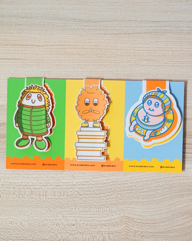 May include: A colorful, three-panel card featuring cartoon characters. The first panel has a green background with a character in a green jacket. The second panel has an orange character on a stack of books. The third panel has a blue background with a character in a hat. The website address and social media handle are at the bottom of each panel.