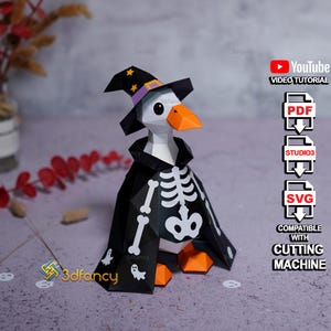 Pode incluir: Um ganso de papel low-poly vestindo um chapéu de bruxa preto com estrelas amarelas e uma faixa roxa, e uma capa preta com uma estampa branca de caixa torácica de esqueleto e pequenos fantasmas. O ganso tem bico e pés laranja e inclui arquivos.