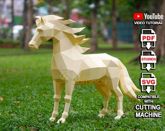 Op de afbeelding: Een papieren model van een paard, gemaakt van wit papier, dat op een groene grasmat staat. Het model is gemaakt van veel polygonen, waardoor het een geometrische uitstraling heeft. De afbeelding bevat ook tekst die "YouTube Video Tutorial", "PDF", "STUDIO3", "SVG", "COMPATIBLE WITH CUTTING MACHINE" zegt.