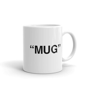 May include: White ceramic mug with black text that reads "MUG" in quotation marks.