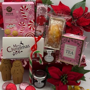 May include: A holiday gift basket containing a pink box of Reids Candy Cane Shortbreads, a white Merry Christmas box, a loaf cake, a box of Afternoon Tea, two jars of preserves, gingerbread cookies, wrapped chocolates, and a candy cane.