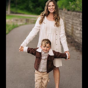 Puede incluir: Un c&aacute;rdigan de canal&eacute; color crema sobre un vestido a juego, combinado con una chaqueta de pana marr&oacute;n con cuello de piel sint&eacute;tica blanca, una camisa de rayas abotonada y pantalones cargo color canela. Las prendas son usadas por dos personas.