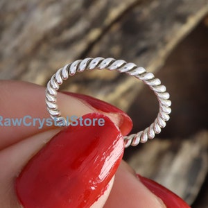 以下が含まれることがあります： ねじれたバンドのシルバーリング。リングはシンプルでエレガントです。