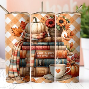 A delightful watercolor illustration featuring a stack of vintage books, surrounded by cream and pastel orange pumpkins, falling autumn leaves, and a cup of hot cocoa. Plaid orange white background. Design is shown on three 20 ounce skinny tumblers.