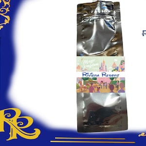 以下が含まれることがあります： ストローが付いた銀色のポーチ。ポーチには、城のカラフルな画像と「マジックキングダム」と「リビエラリゾート」の文字が書かれています。