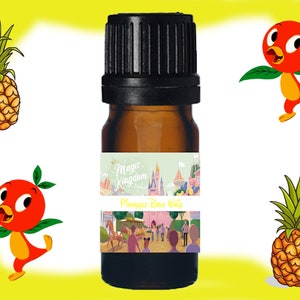 Könnte beinhalten: Eine kleine braune Glasflasche mit schwarzem Verschluss. Die Flasche hat ein Etikett mit einem Cartoon-Bild von Schloss Aschenputtel und dem Text "Magic Kingdom Pineapple Dole Whip".