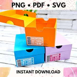 May include: Three colorful gift boxes stacked on top of each other. The top box is orange and says "Buon Compleanno Teresa Da Noi". The middle box is blue and says "Battesimo Luca". The bottom box is purple and says "Comunione Elisa".