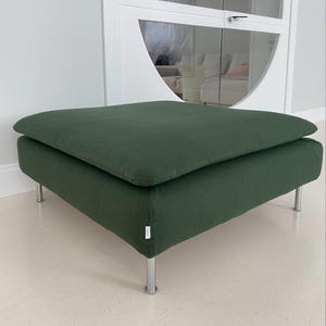 May include: A dark green square ottoman with a cushioned top and silver metal legs.