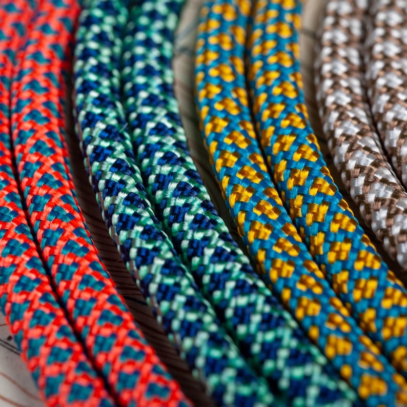May include: Close-up of four colorful braided ropes with different patterns. The ropes are red, blue, yellow, and gray.