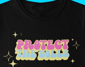 May include: Black t-shirt with the text "PROTECT THE BALLS" in pink and blue letters with yellow stars.